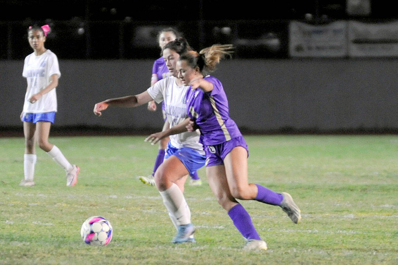 Sequim’s Ruby Moxley-Horgan, right, jockeys for position during the Wolves’ 5-0 win over Olympic at home on Thursday. (Matthew Nash/Olympic Peninsula News Group)