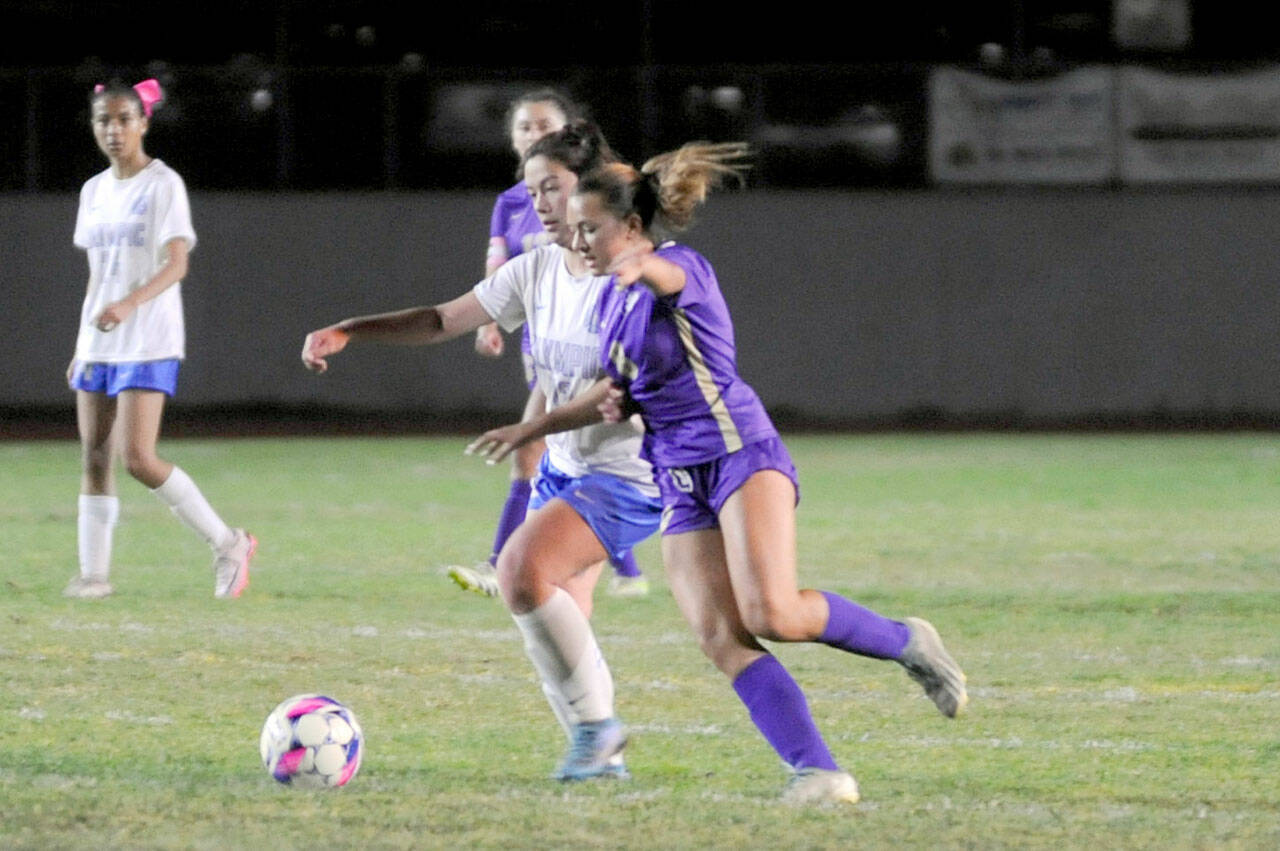 Sequim’s Ruby Moxley-Horgan, right, jockeys for position during the Wolves’ 5-0 win over Olympic at home on Thursday. (Matthew Nash/Olympic Peninsula News Group)