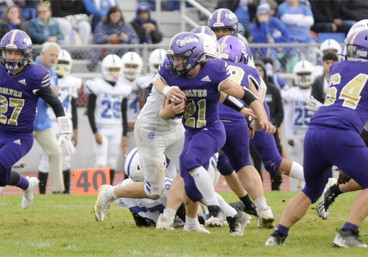 Sequim's Aaron Golbeck (21) looks for yardage against Olympic in a delayed game Saturday. The Wolves were able to move the ball on Olympic but mistakes hurt them in a 28-7 loss. (Matthew Nash/Olympic Peninsula News Group)