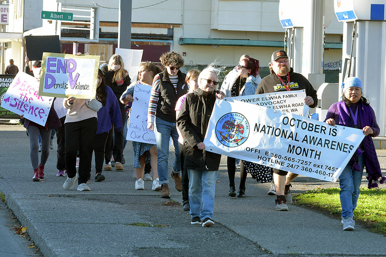 Participants in the a walk to raise awareness of domestic violence make their way down First Street on a journey from the Elwha Heritage Center to Healthy Families of Clallam County in Port Angeles on Wednesday. The event also included resource booths, shared stories and food and beverages, hosted by the Lower Elwha Klallam Tribe. (Keith Thorpe/Peninsula Daily News)