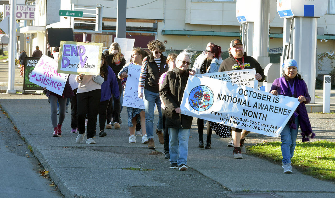 Participants in the a walk to raise awareness of domestic violence make their way down First Street on a journey from the Elwha Heritage Center to Healthy Families of Clallam County in Port Angeles on Wednesday. The event also included resource booths, shared stories and food and beverages, hosted by the Lower Elwha Klallam Tribe. (Keith Thorpe/Peninsula Daily News)