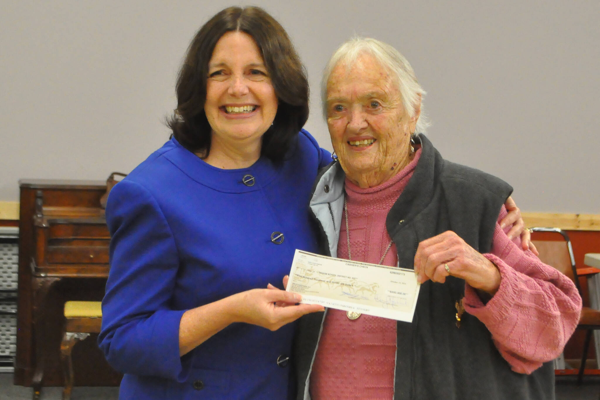 Marylaura Ramponi donates a $500,000 check on Oct. 17 to Sequim School District superintendent Regan Nickels for the Ramponi Center for Technical Excellence, a vocational building at Sequim High School. The check was made in honor of Marylaura’s husband Louie, as it would have been his 89th birthday. (Matthew Nash/Olympic Peninsula News Group)