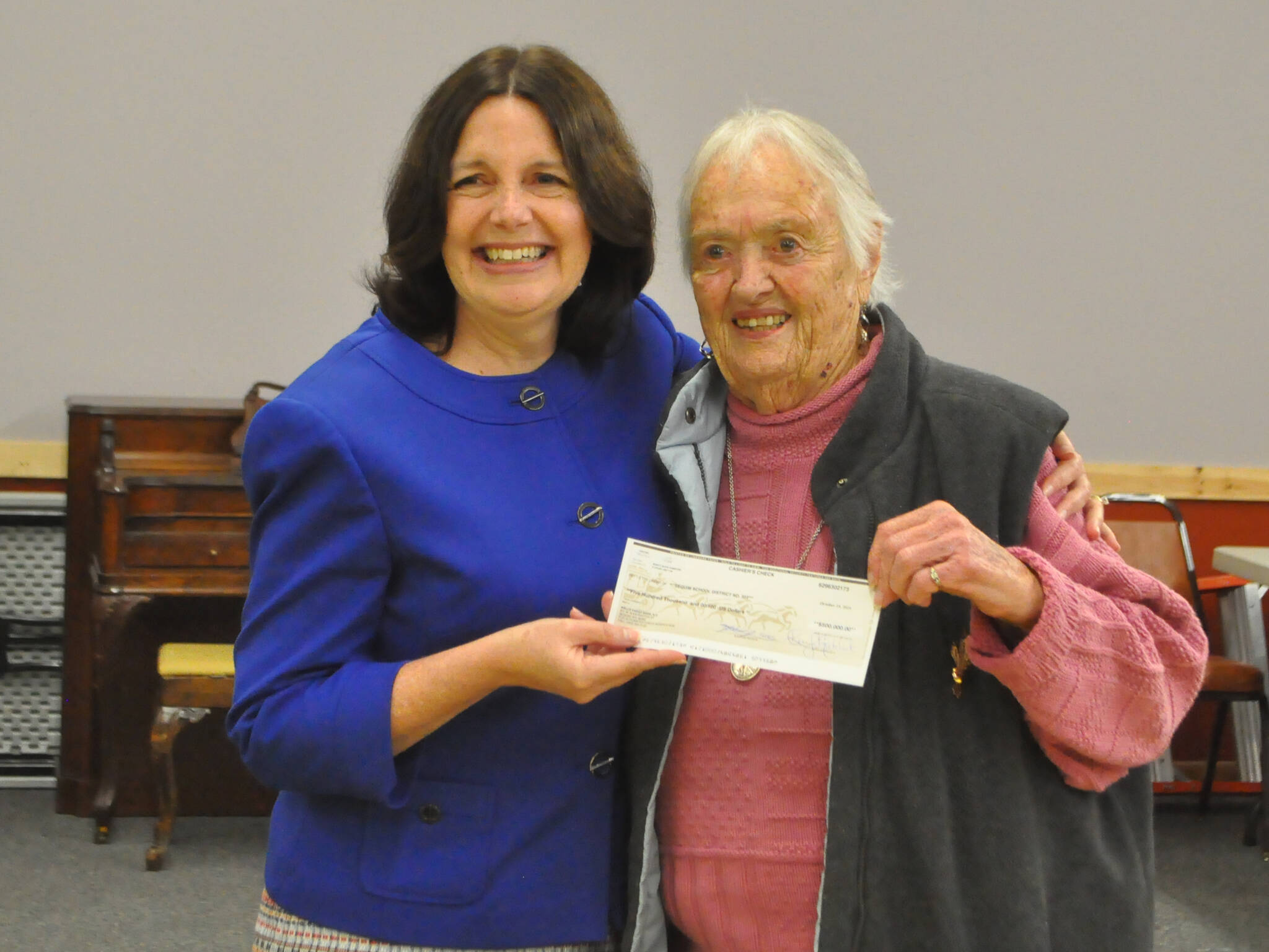 Marylaura Ramponi donates a $500,000 check on Oct. 17 to Sequim School District superintendent Regan Nickels for the Ramponi Center for Technical Excellence, a vocational building at Sequim High School. The check was made in honor of Marylaura’s husband Louie, as it would have been his 89th birthday. (Matthew Nash/Olympic Peninsula News Group)