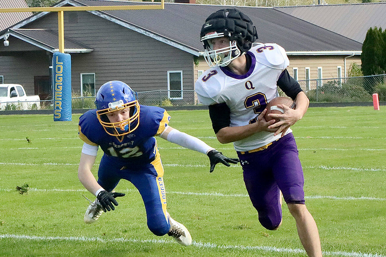 Quilcene’s Robert Evans (3) barely evades the flying tackle of Crescent’s Mikah Love (12). Evans had two 60-yard touchdown runs on the day. Dave Logan/for Peninsula Daily News