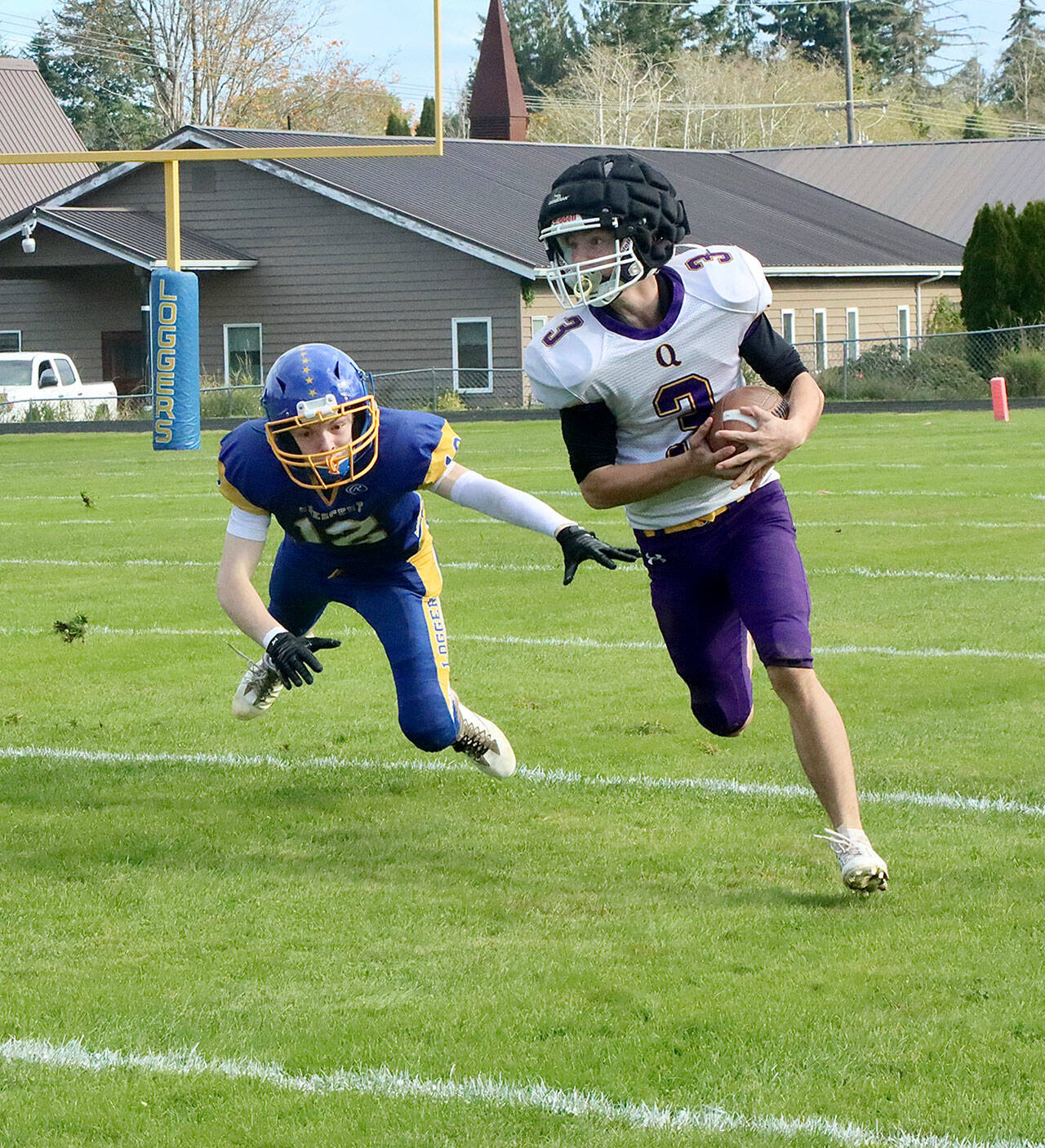 Quilcene’s Robert Evans (3) barely evades the flying tackle of Crescent’s Mikah Love (12). Evans had two 60-yard touchdown runs on the day. Dave Logan/for Peninsula Daily News