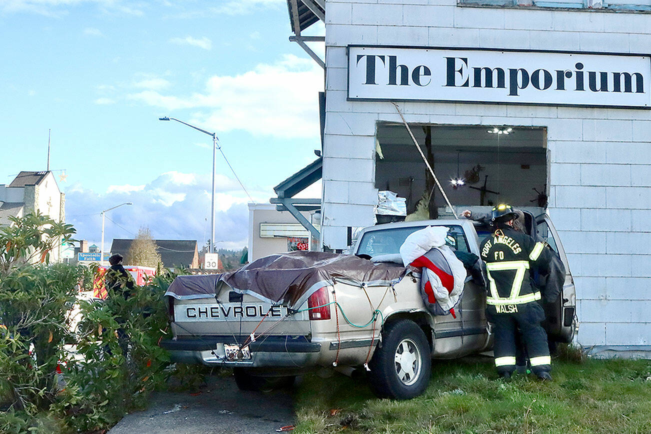 There were no serious injuries after a two-car collision pushed a Chevrolet pickup truck into the corner of the Emporium building at the corner of Eighth and Cherry streets in Port Angeles. (Dave Logan/for Peninsula Daily News)