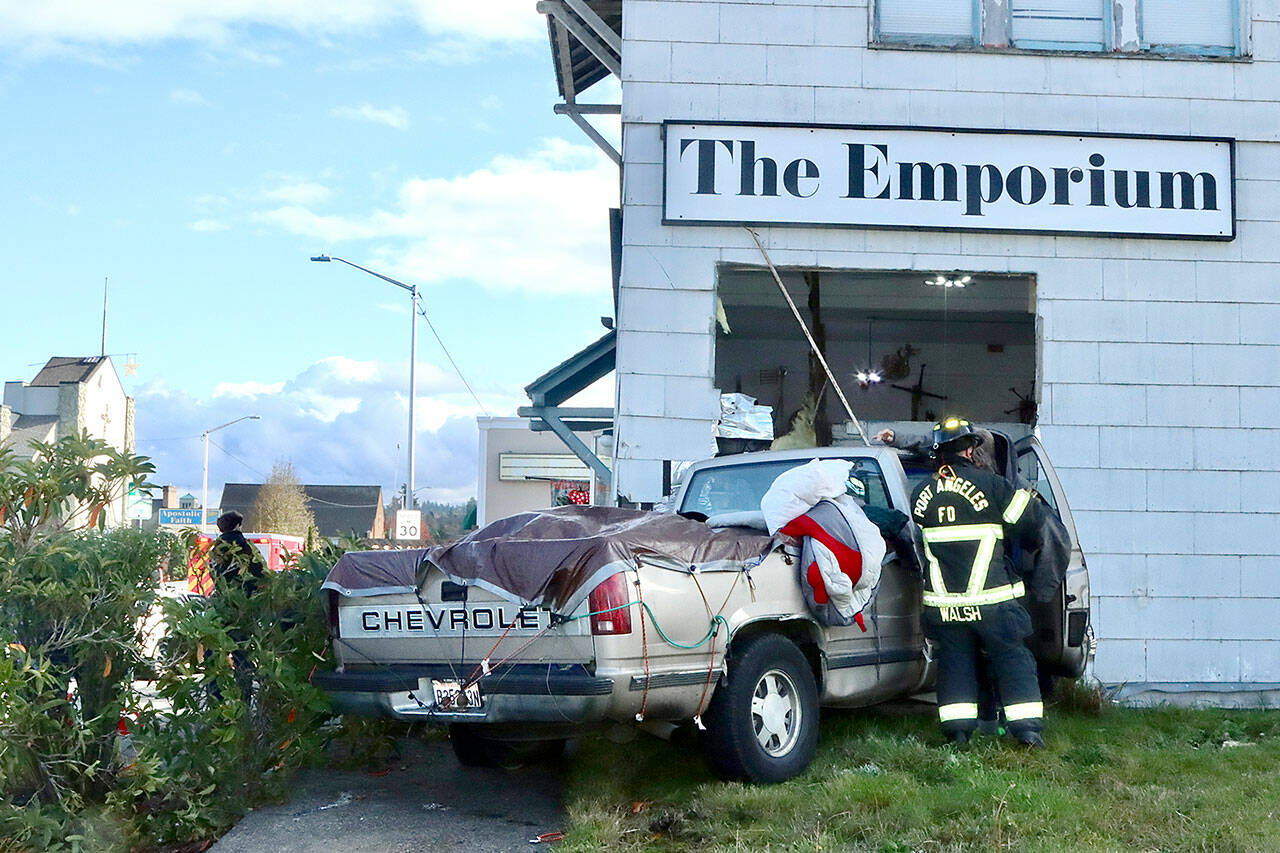 There were no serious injuries after a two-car collision pushed a Chevrolet pickup truck into the corner of the Emporium building at the corner of Eighth and Cherry streets in Port Angeles. (Dave Logan/for Peninsula Daily News)