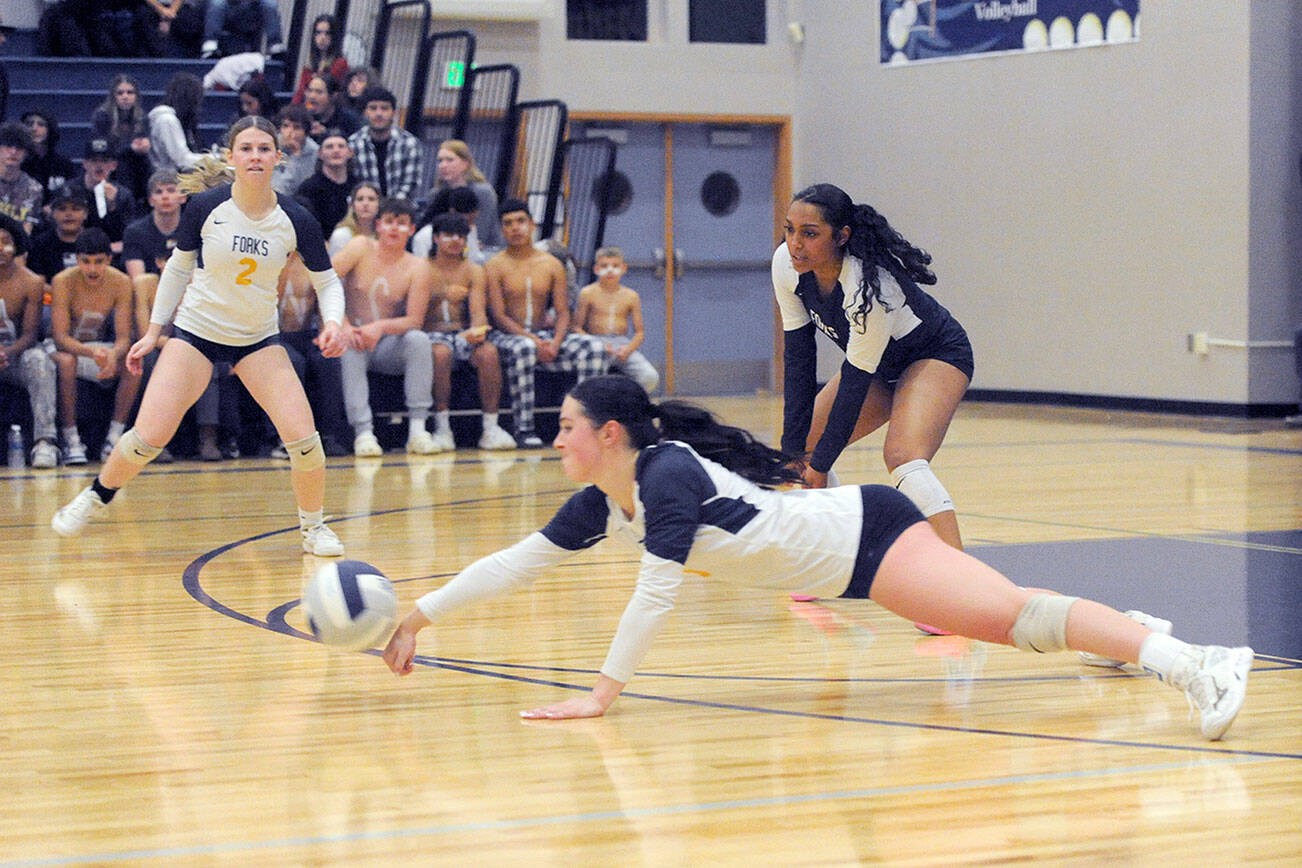 Hustle played a big role towards Forks winning the Class 2B Pacific League championship Wednesday night in the Spartan gym where Forks defeated Raymond-South Bend 3-0. Forks' Chloe Gaydeski dives for the dig while teammates Bailey Johnson (2) and Eladia Hernandez-Stansbury look on. 
Photo by Lonnie Archibald.