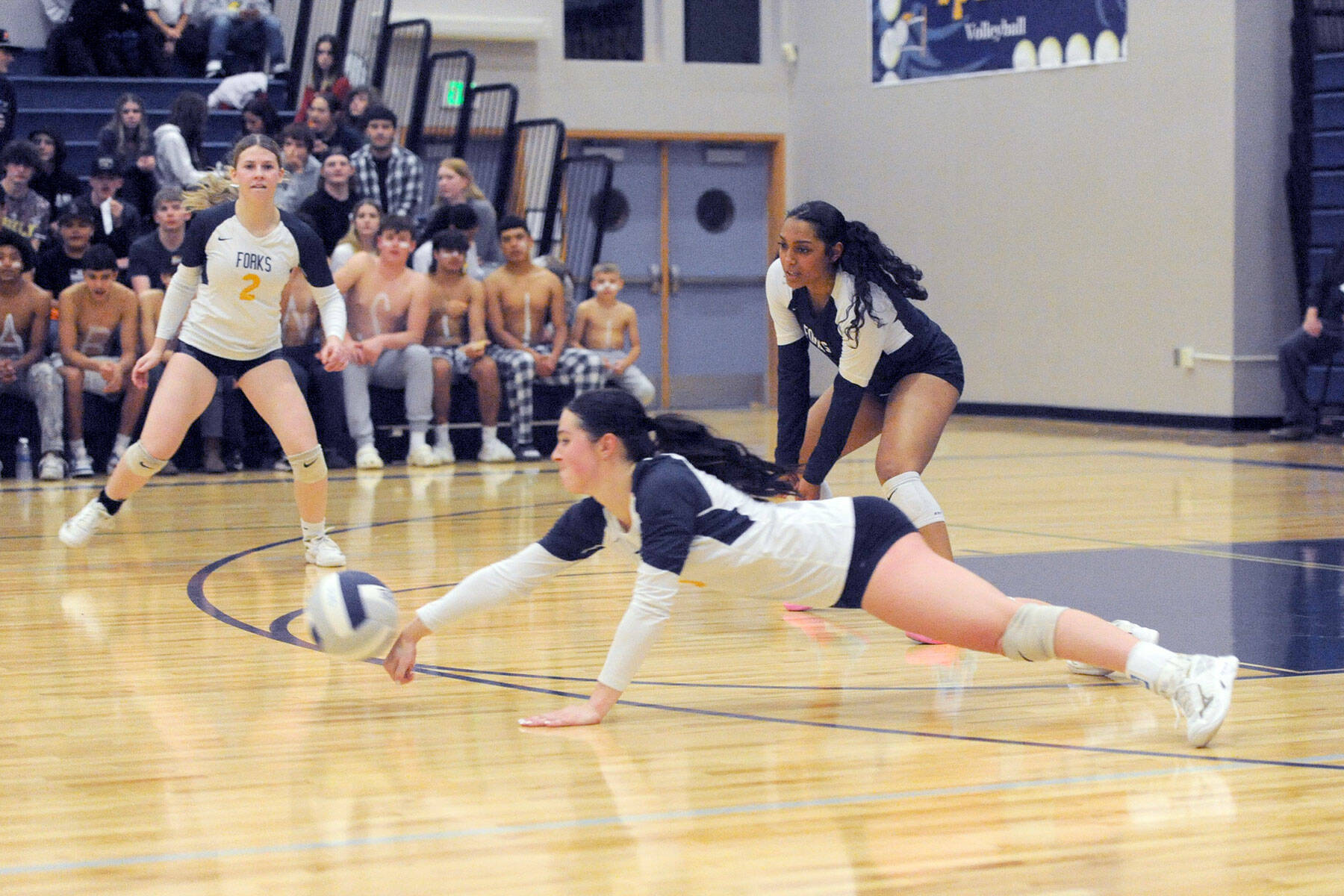 Hustle played a big role towards Forks winning the Class 2B Pacific League championship Wednesday night in the Spartan gym where Forks defeated Raymond-South Bend 3-0. Forks’ Chloe Gaydeski dives for the dig while teammates Bailey Johnson (2) and Eladia Hernandez-Stansbury look on. Photo by Lonnie Archibald.