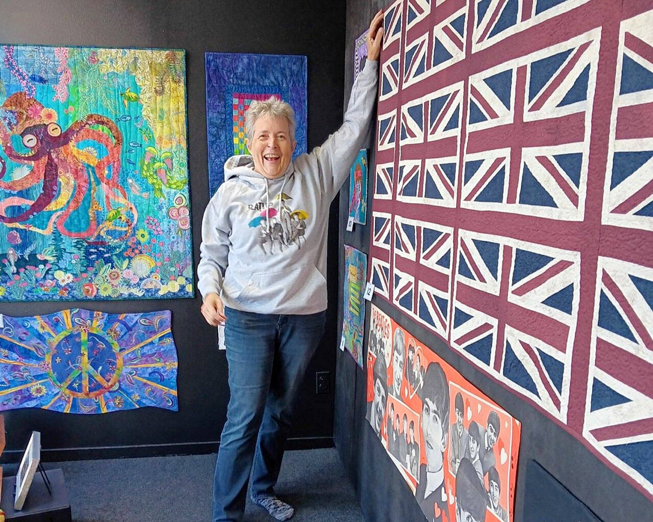 Port Angeles textile artist Merrie Jo Schroeder, installing the “Beatlemania” walk-by exhibit at 675 Tyler St., Port Townsend. The display of Beatles memorabilia and Beatles-themed art quilts and textile pieces will continue through November.