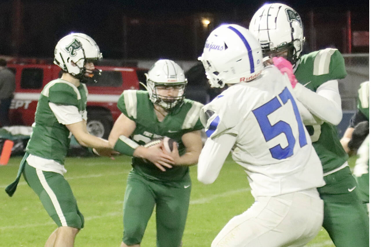 Port Angeles quarterback Blake Sohlberg hands off to running back Dylan Mann on Friday night at Port Angeles Civic Field against Olympic. (Dave Logan/for Peninsula Daily News)