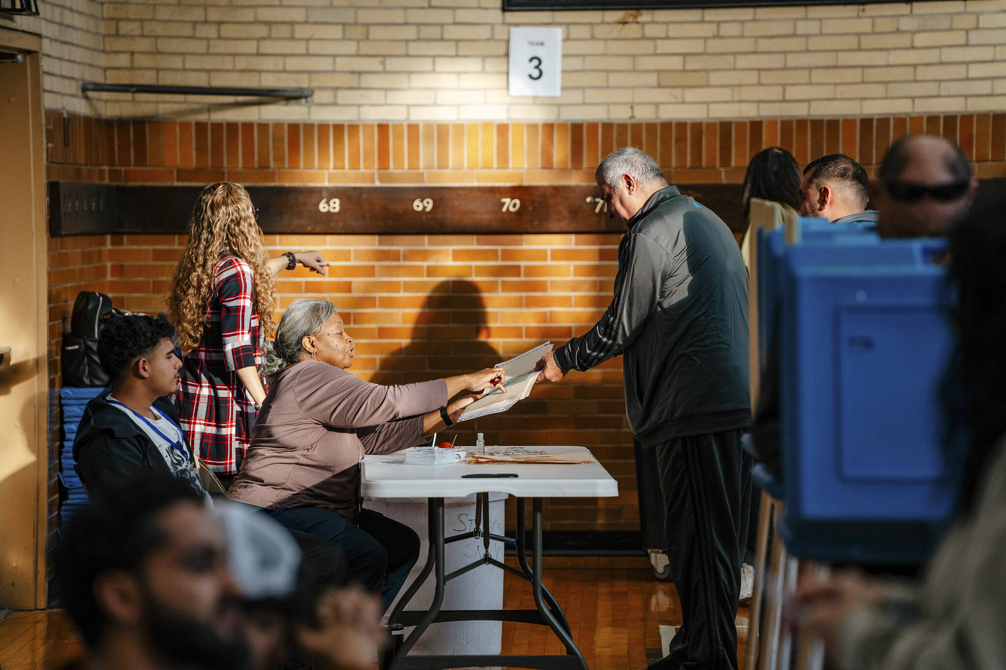 A voter is handed as ballot at Woodworth School in Dearborn, Mich., on Tuesday. One of the most consequential presidential elections in the nation’s modern history is well underway, as voters flocked to churches, schools and community centers to shape the future of American democracy. (Nick Hagen/The New York Times)