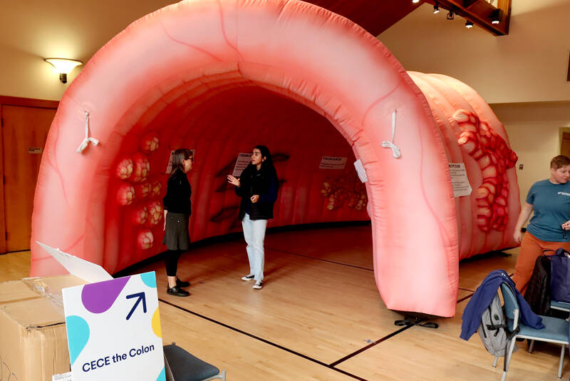 Lisa Bridge of Sequim is given a tour by Cithlali Chavez of Fred Hutch Cancer Center inside the giant inflatable colon discussing colon health on Wednesday at the Port Angeles Senior Center’s health and wellness fair. Representatives from Olympic Medical Center, Jamestown Family Health Clinic, North Olympic Healthcare, Clallam County Health and Human Services, Elwha Klallam Tribe and Peninsula Behavior Health were present to answer questions. (Dave Logan/for Peninsula Daily News)