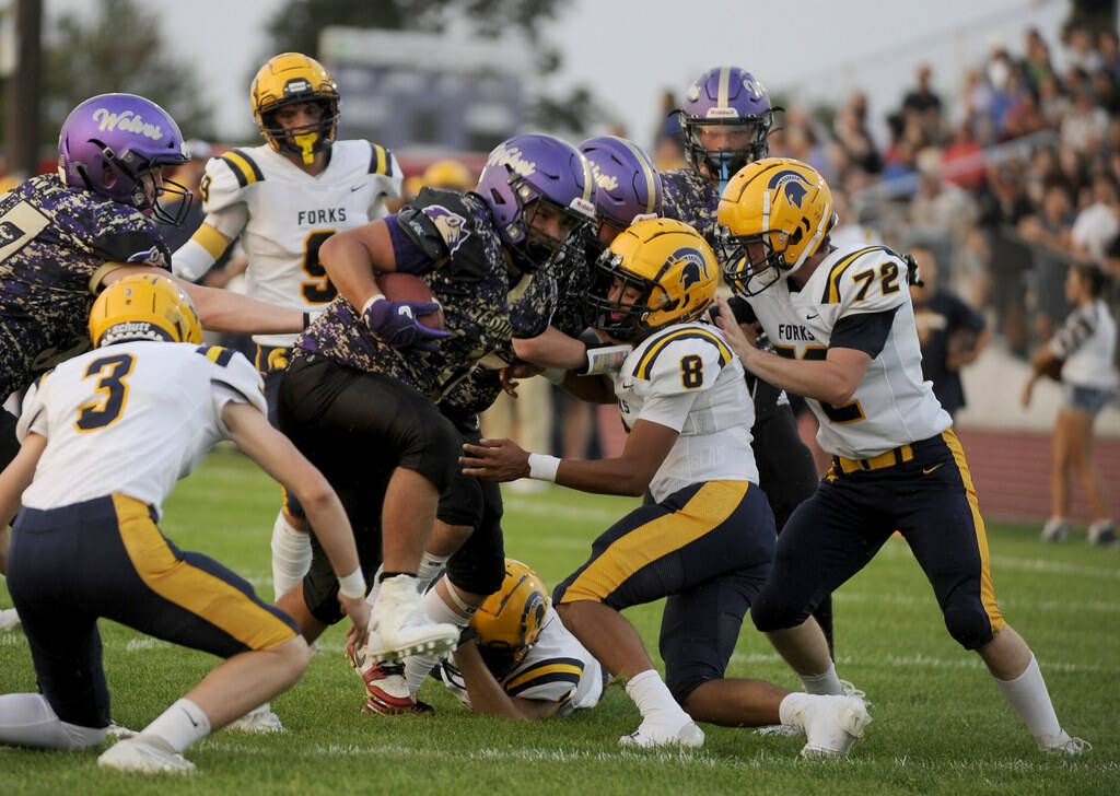 Michael Dashiell/Olympic Peninsula News Group 
Sequim’s Lars Wiker, with ball, is tackled by, from left, Forks’ Gage Willenbrink, Bubba Hernandez and Sawyer Graham. Hernandez, Graham and Willenbrink were all honored in all-league voting by Class 2B Central League West Division coaches.