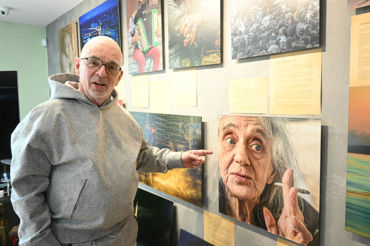 Sequim photographer Randy Tomaras points to a photo featured in his two-volume course “It Is NOT the Camera.” Tomaras’ home studio will be featured in the Strait from the Artists Studio Tour today and Sunday. (Michael Dashiell/Olympic Peninsula News Group)