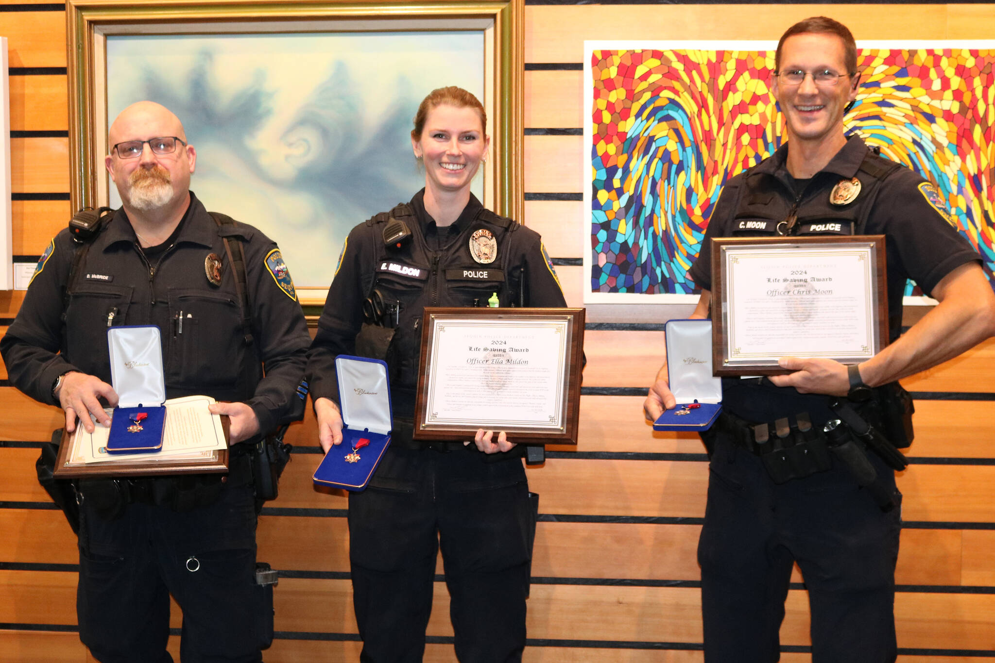 Sequim Police officers, from left, Devin McBride, Ella Mildon and Chris Moon receive 2024 Lifesaving Awards on Oct. 28 for their medical response to help a man after he was hit by a truck on U.S. Highway 101. (Barbara Hanna)