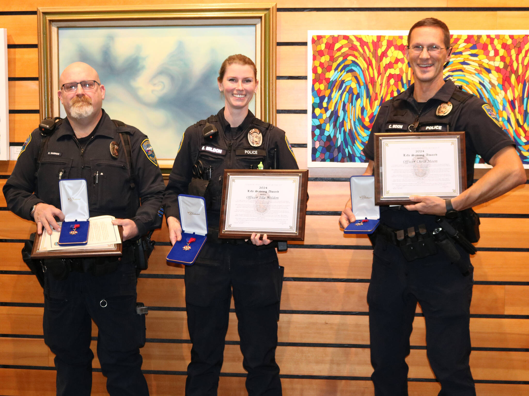 Sequim Police officers, from left, Devin McBride, Ella Mildon and Chris Moon receive 2024 Lifesaving Awards on Oct. 28 for their medical response to help a man after he was hit by a truck on U.S. Highway 101. (Barbara Hanna)