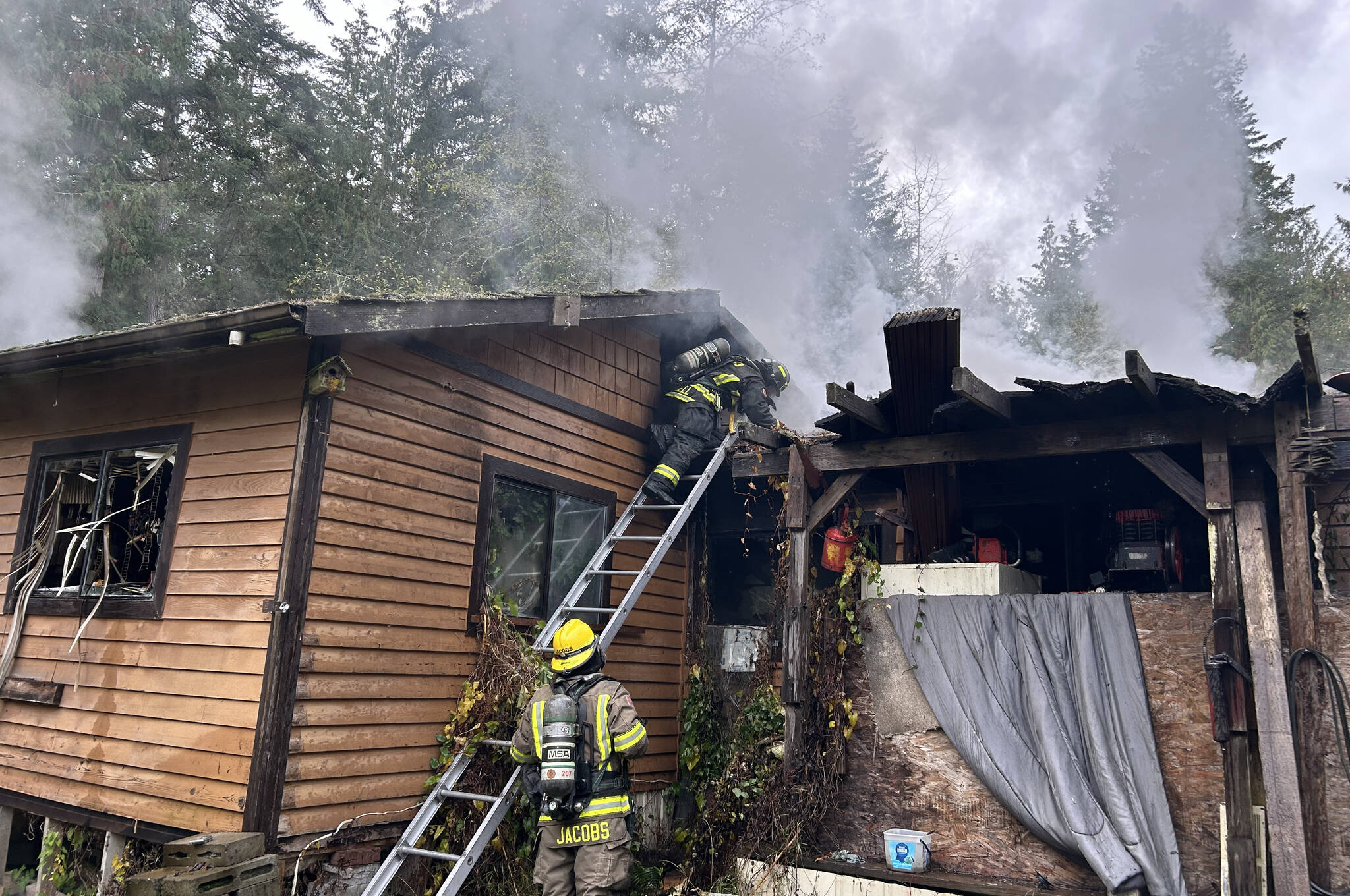 Firefighters with Clallam County Fire District 3 work to extinguish a fire Tuesday afternoon in the 100 block of Barnes Road. (Matthew Nash/Olympic Peninsula News Group)