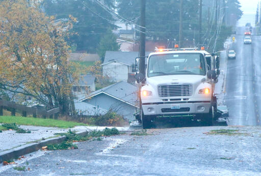 A street sweeper on I Street in Port Angeles cleans up the street along the curbs of all the debris that blew down during Tuesday evening’s storm. Thousands were without power at the peak of the storm. (Dave Logan/for Peninsula Daily News)