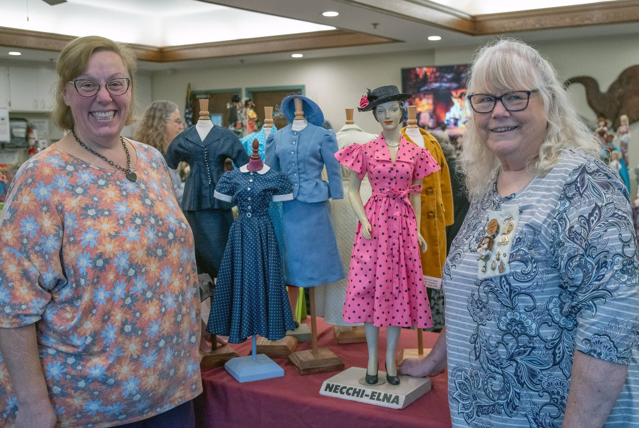 Emily Matthiessen/Olympic Peninsula News Group
Christine Brehan, left, Olympic Peninsula Doll Club president, and Sandy Brehan, cofounder of the group, share some of Sandy’s collection of miniature mannequins dressed in clothes that she made from original 1930s-1950s patterns. The blue skirt suit on the left was made by another member. The Brehans shared some of their collections with visitors and residents of Sherwood Assisted Living.