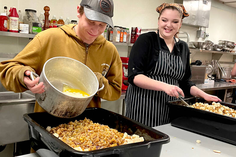 Lincoln High School students Azrael Harvey, left, and Tara Coville prepare dressing that will be part of 80 Thanksgiving dinners made from scratch and sold by the Salish Sea Hospitality and Ecotourism program. All meal preparation had to be finished by today, when people will pick up the grab-and-go meals they ordered for Thursday’s holiday. (Paula Hunt/Peninsula Daily News)