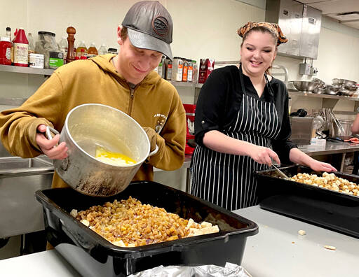 Lincoln High School students Azrael Harvey, left, and Tara Coville prepare dressing that will be part of 80 Thanksgiving dinners made from scratch and sold by the Salish Sea Hospitality and Ecotourism program. All meal preparation had to be finished by today, when people will pick up the grab-and-go meals they ordered for Thursday’s holiday. (Paula Hunt/Peninsula Daily News)