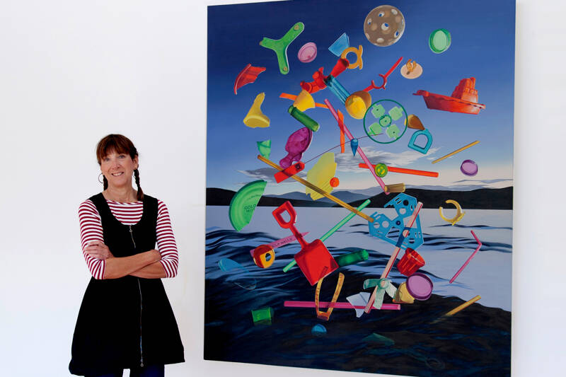 Artist Karen Hackenberg in her Discovery Bay home studio with her painting titled “The Floating World.” (photo by Craig Wester)