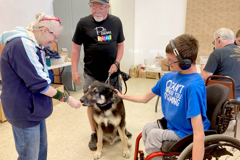 From left, Gail Jangarrd, Bob Dunbar and Sammy Dionne treat a lucky dog to a biscuit made with organic, healthy and human-grade ingredients.