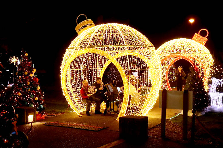 The outside of the Vern Burton Community Center is decorated with giant Christmas balls and lighted trees on Wednesday for the opening ceremonies of the Festival of Trees. “White Christmas” was played by the Port Angeles Symphony Orchestra’s brass quintet and then sung by Amanda Bacon. (Dave Logan/for Peninsula Daily News)