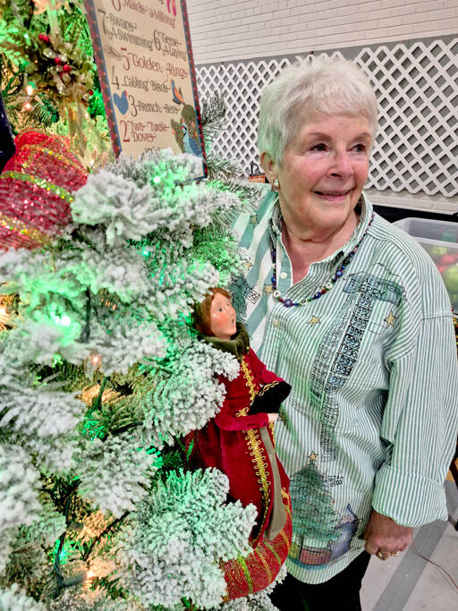 Sherry Phillips, chair of the Festival of Trees design committee, stands next to the tree Twelve Days of Christmas, which she designed personally. (Leah Leach/for Peninsula Daily News)