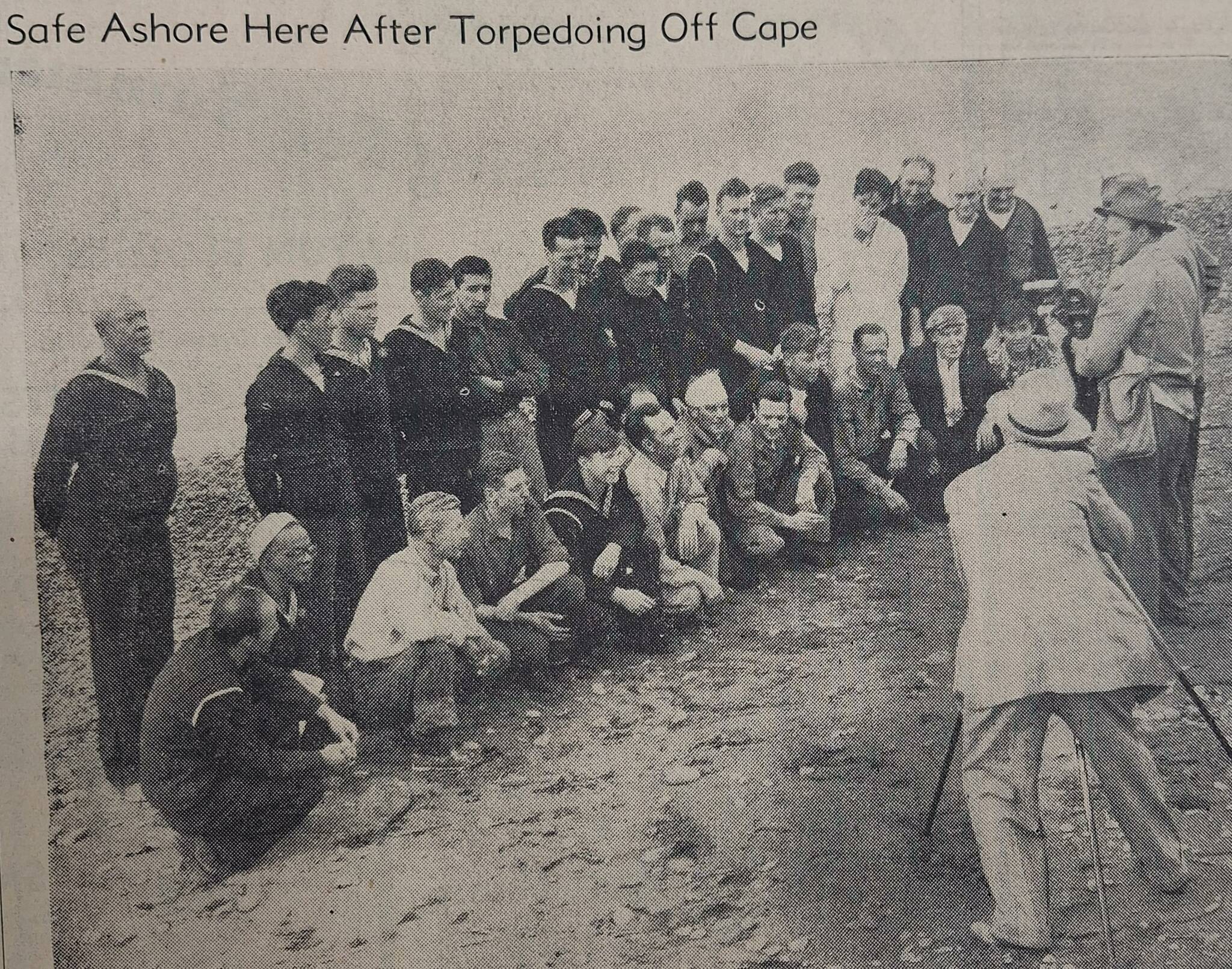 31 members of the crew on the beach in Port Angeles standing before news photographers.	(submitted photo)