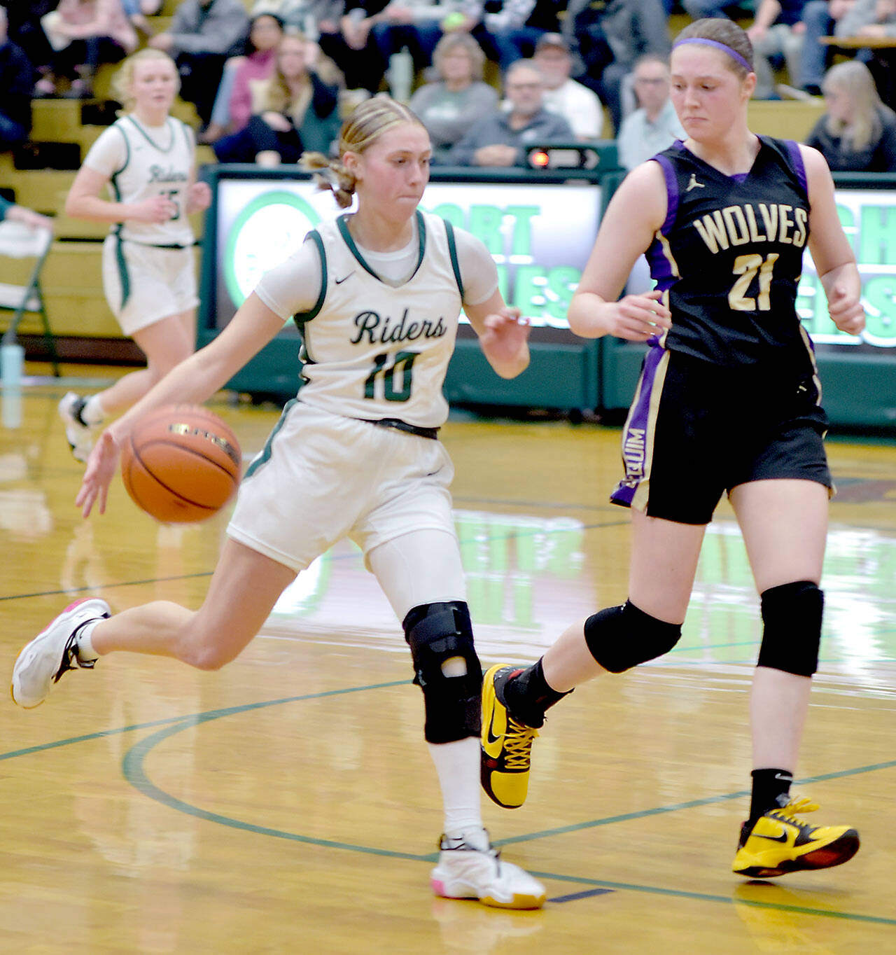 KEITH THORPE/PENINSULA DAILY NEWS Port Angeles’ Teanna Clark, left, takes to ball to the lane as Sequim’s Libby Turella follows along on Tuesday in Port Angeles.