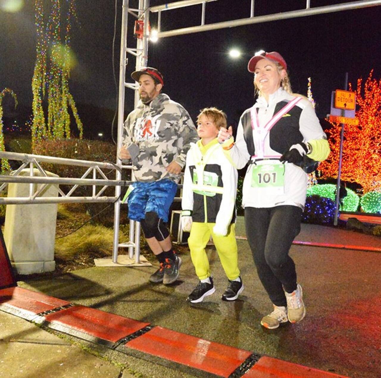 Taren Reaves of Forks (No. 101) leads a group across the finish line after dark in Blyn at the Jamestown SKlallam Glow Run on Saturday night. (Run the Peninsula)