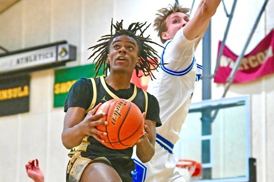 Peninsula College's Akeem Sulaiman drives to the hoop Saturday in Port Angeles against Silas Wright (10) and Ben Thornbrue of Lane.Sulaiman scored 20 to go with 12 rebounds. (Jay Cline/Peninsula College)