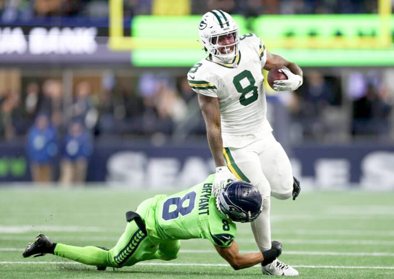 Green Bay quarterback Jordan Love tries to get away from Seattle's Coby Bryant in Sunday night's game at Lumen Field in Seattle. Green Bay won 30-13. (Steph Chambers/Getty Images)