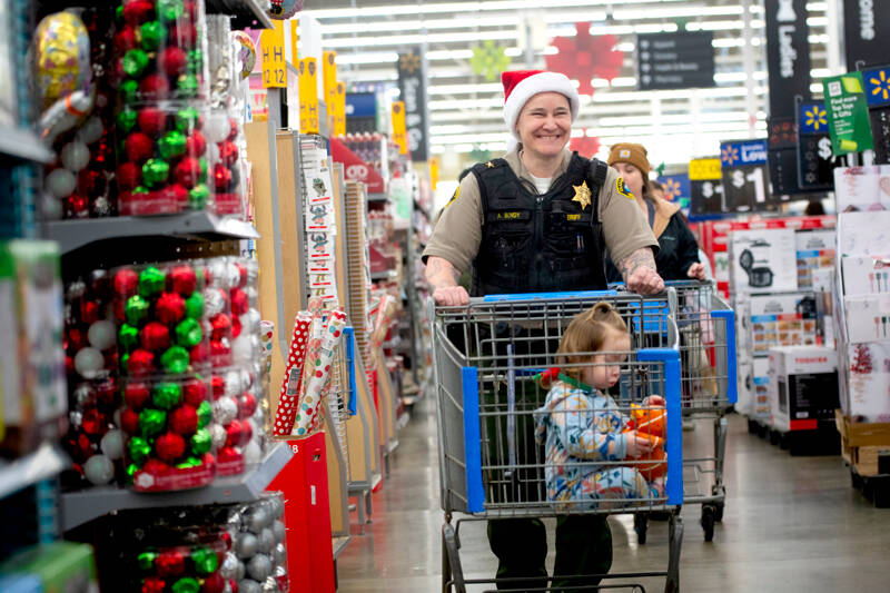 Clallam County Sheriff’s Office Chief Criminal Deputy Amy Bundy shops with a child during the Shop with a Hero event on Dec. 7. (Jesse Major)