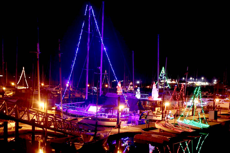 Many colorful Christmas lights that adorn sailboats reflect in the calm waters at Port Angeles Boat Haven. The weather forecast predicts high temperature in the low 50s across the Peninsula this weekend with an increased chance for showers on Saturday and Sunday. (Dave Logan/for Peninsula Daily News)