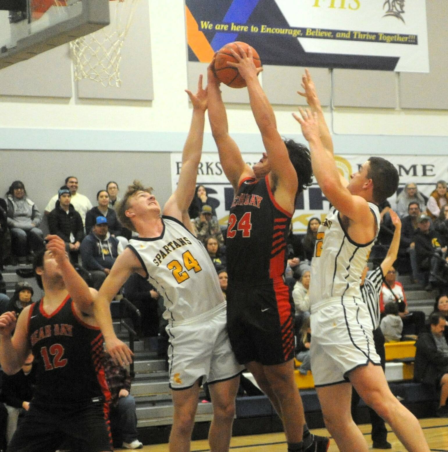 Lonnie Archibald/for Peninsula Daily News
Forks’ Landon Olson (24) and Brody Lausche challenge Neah Bay’s Tyler Swan inside for the rebound while Red Devil Daniel Cumming looks on.