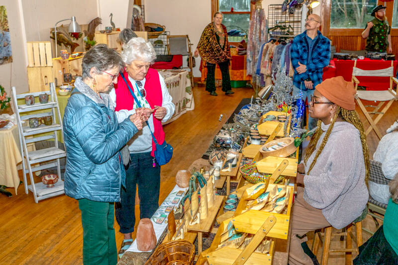 Judy Davidson, left, and Kathy Thomas, both of Port Townsend, look over the skin care products offered by Shandi Motsi of Port Townsend, one of the 20 vendors at the second annual Procrastinators Craft Fair at the Palindrome/Eaglemount Cidery on Friday. (Steve Mullensky/for Peninsula Daily News)