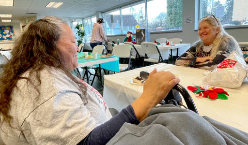 Ellen White Face, left, and Dora Ragland enjoy some conversation after finishing a Christmas dinner prepared by Salvation Army Port Angeles staff and volunteers. The Salvation Army anticipated serving 120-150 people at its annual holiday meal on Tuesday. (Paula Hunt/Peninsula Daily News)