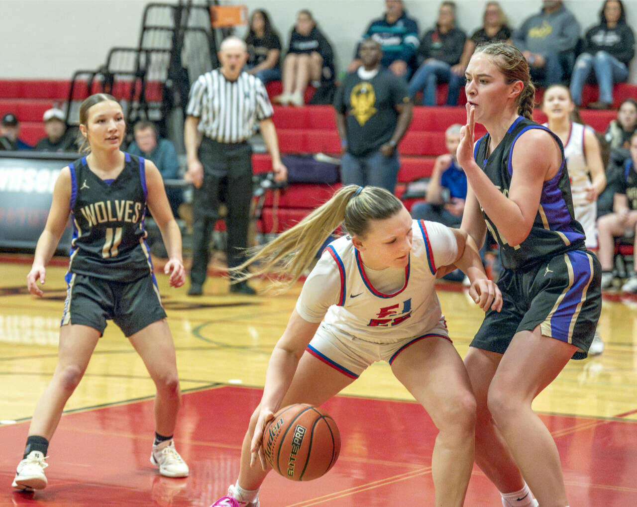 East Jefferson Teri Wiley battles for inside position against the defense of Sequim’s Hailey Wagner. Also in on the play is Sequim’s Kiley Winter. (Steve Mullensky/for Peninsula Daily News)