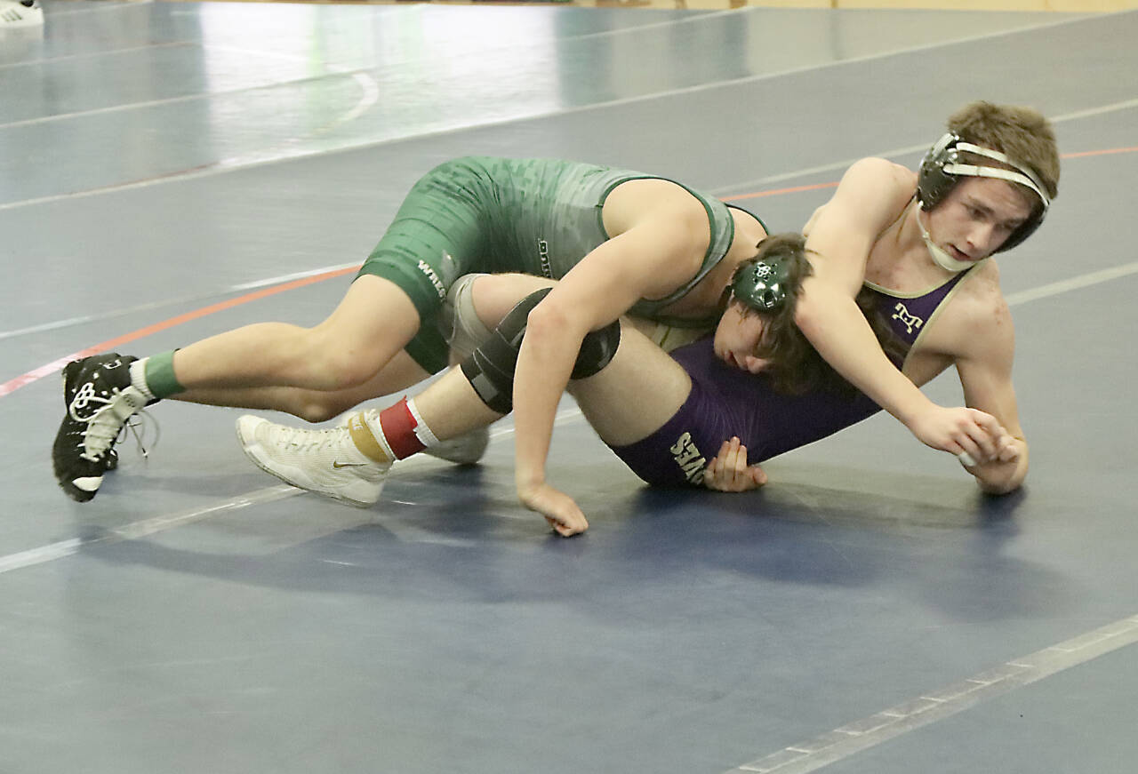 In a dual meet between Port Angeles and Sequim at the annual Battle of the Axe teams duals tournament, Port Angeles’ Drew Disher, left takes on Sequim’s Riley Downs in the 150-pound division. Disher won 22-7 and Port Angeles edged out a 33-29 win over the Wolves. (Dave Logan/for Peninsula Daily News)