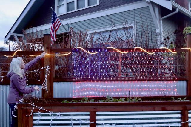 Shanna Bloom, who lives at the intersection of Fifth and Cherry streets in Port Angeles, plans to keep her American flag lights up well into spring. "These aren't Christmas lights anymore," she said. "They are patriotic lights now." (Dave Logan/for Peninsula Daily News)