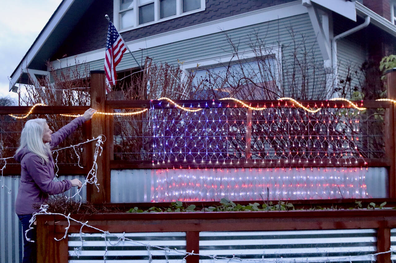 Shanna Bloom, who lives at the intersection of Fifth and Cherry streets in Port Angeles, plans to keep her American flag lights up well into spring. “These aren’t Christmas lights anymore,” she said. “They are patriotic lights now.” (Dave Logan/for Peninsula Daily News)