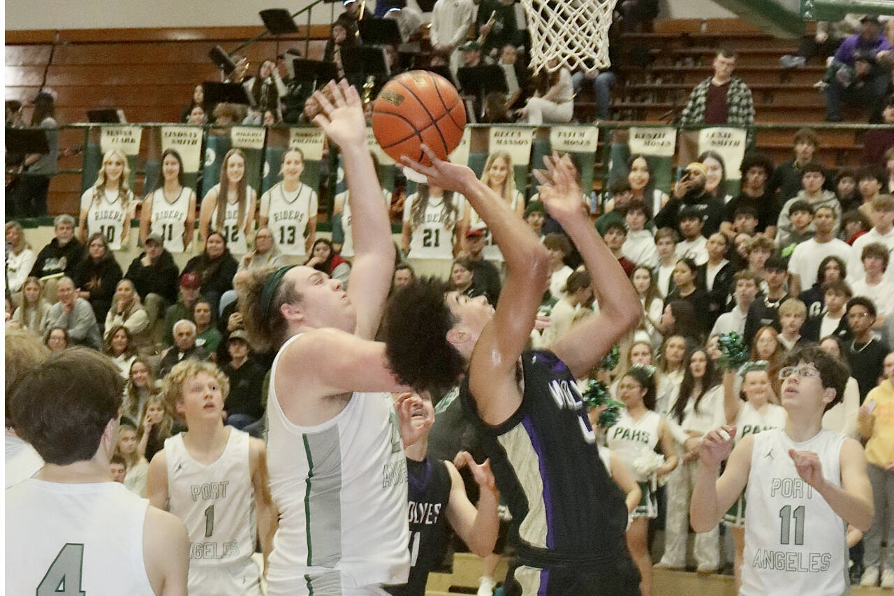 Sequim;'s Jericho Julmist goes up for a layup against the defense of Port Angeles' Brock Hope. Also in on the play are Port Angeles' Blake Sohlberg (4), Matthew Miller (1) and Brody Pierce (11). Dave Logan/for Peninsula Daily News