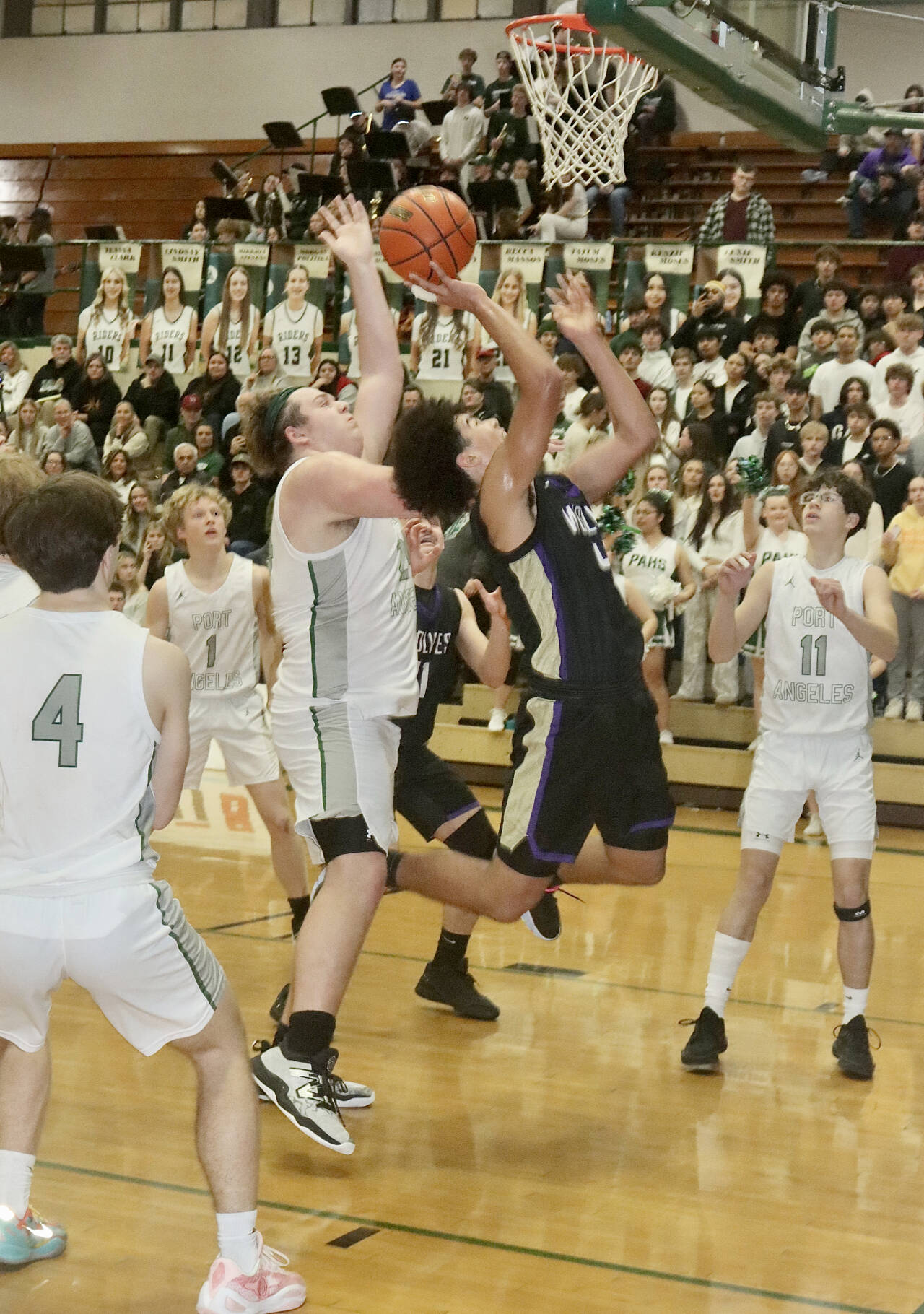 Sequim’s Jericho Julmist goes up for a layup against the defense of Port Angeles’ Brock Hope. Also in on the play are Port Angeles’ Blake Sohlberg (4), Matthew Miller (1) and Brody Pierce (11). Dave Logan/for Peninsula Daily News