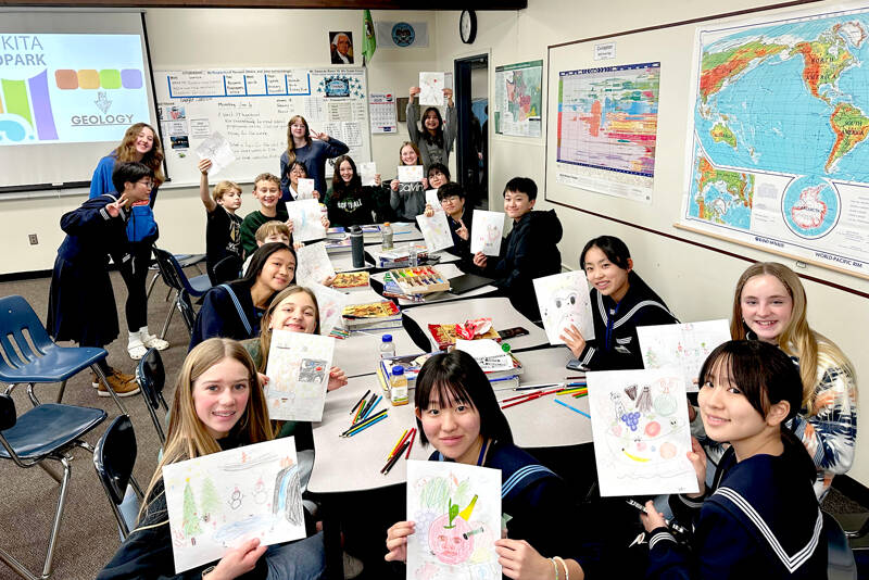 Students from Mutsu City, Japan, and Port Angeles sit in a Stevens Middle School classroom eating lunch before the culture fair on Tuesday. To pass the time, they decided to have a drawing contest between themselves. (Rob Edwards)