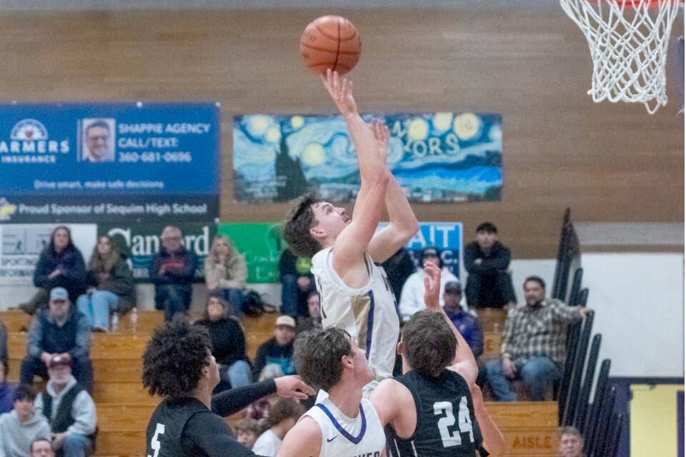 Sequim’s Charlie Grider goes up for a shot surrounded by North Kitsap defenders Friday as teammate Mason Rapelje (20) is in on the play. The Wolves beat the Vikings 74-46. (Emily Matthiessen/Olympic Peninsula News Group)