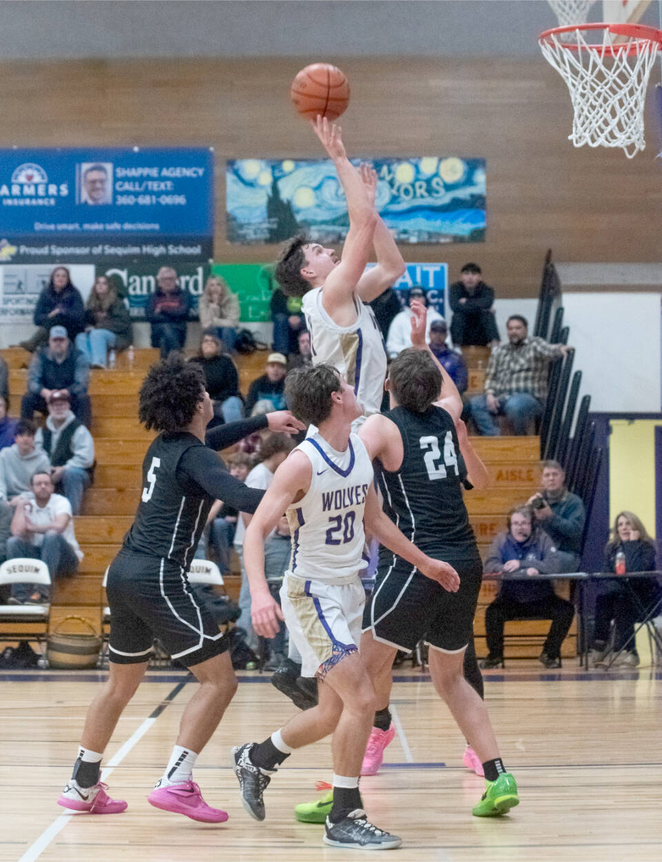 Sequim’s Charlie Grider goes up for a shot surrounded by North Kitsap defenders Friday as teammate Mason Rapelje (20) is in on the play. The Wolves beat the Vikings 74-46. (Emily Matthiessen/Olympic Peninsula News Group)