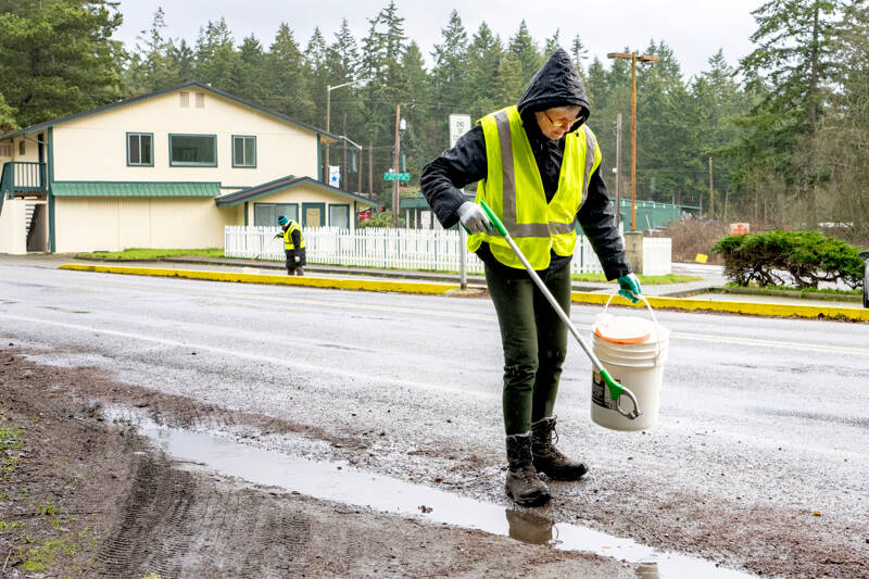 Phyllis Becker of Port Hadlock, foreground, and Wendy Davis of Port Townsend, volunteers with the Jefferson County Trash Task Force, pick up litter along Discovery Road on Sunday during the first trash pickup of the year. (Steve Mullensky/for Peninsula Daily News)